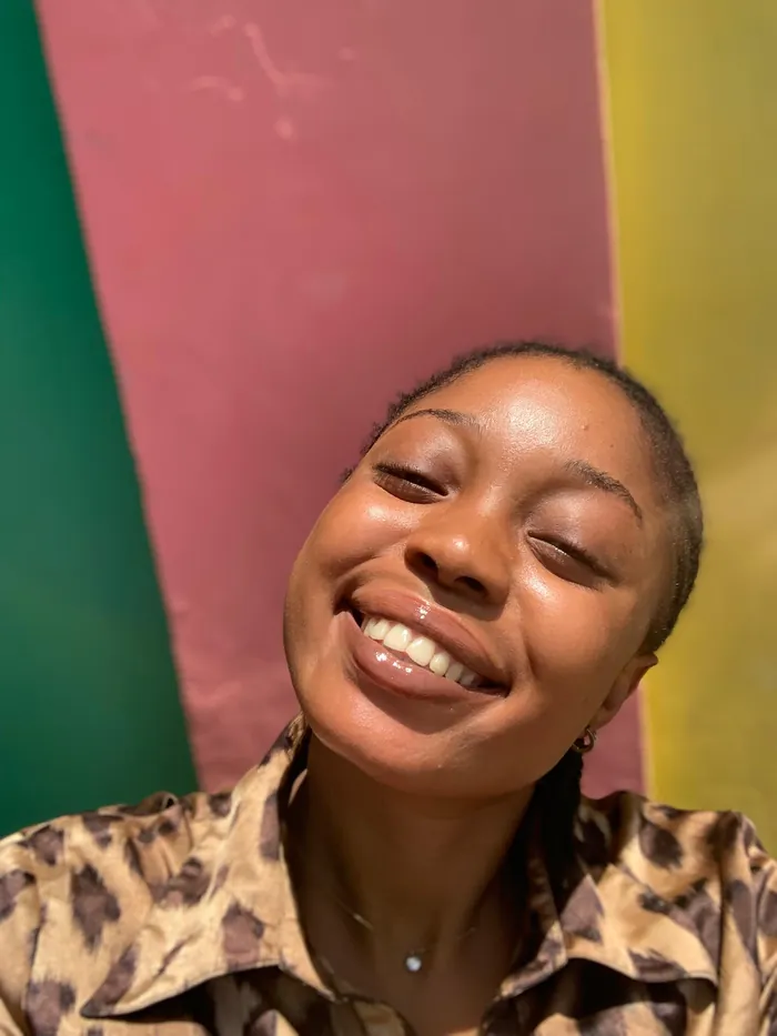 Angela laughing out loud, bare-faced, in a leopard-print shirt